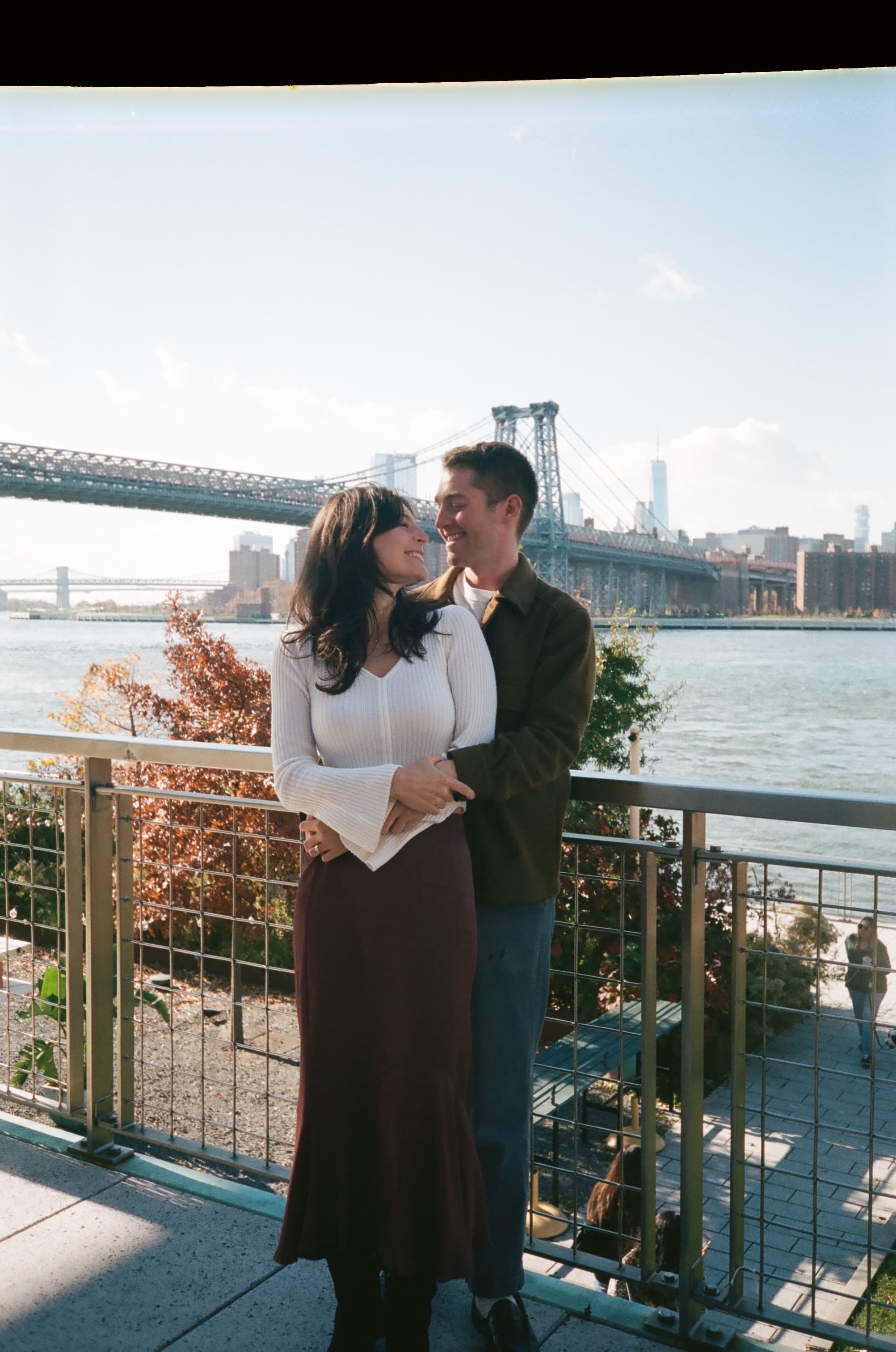 Emily and Will looking at each other by the bridge