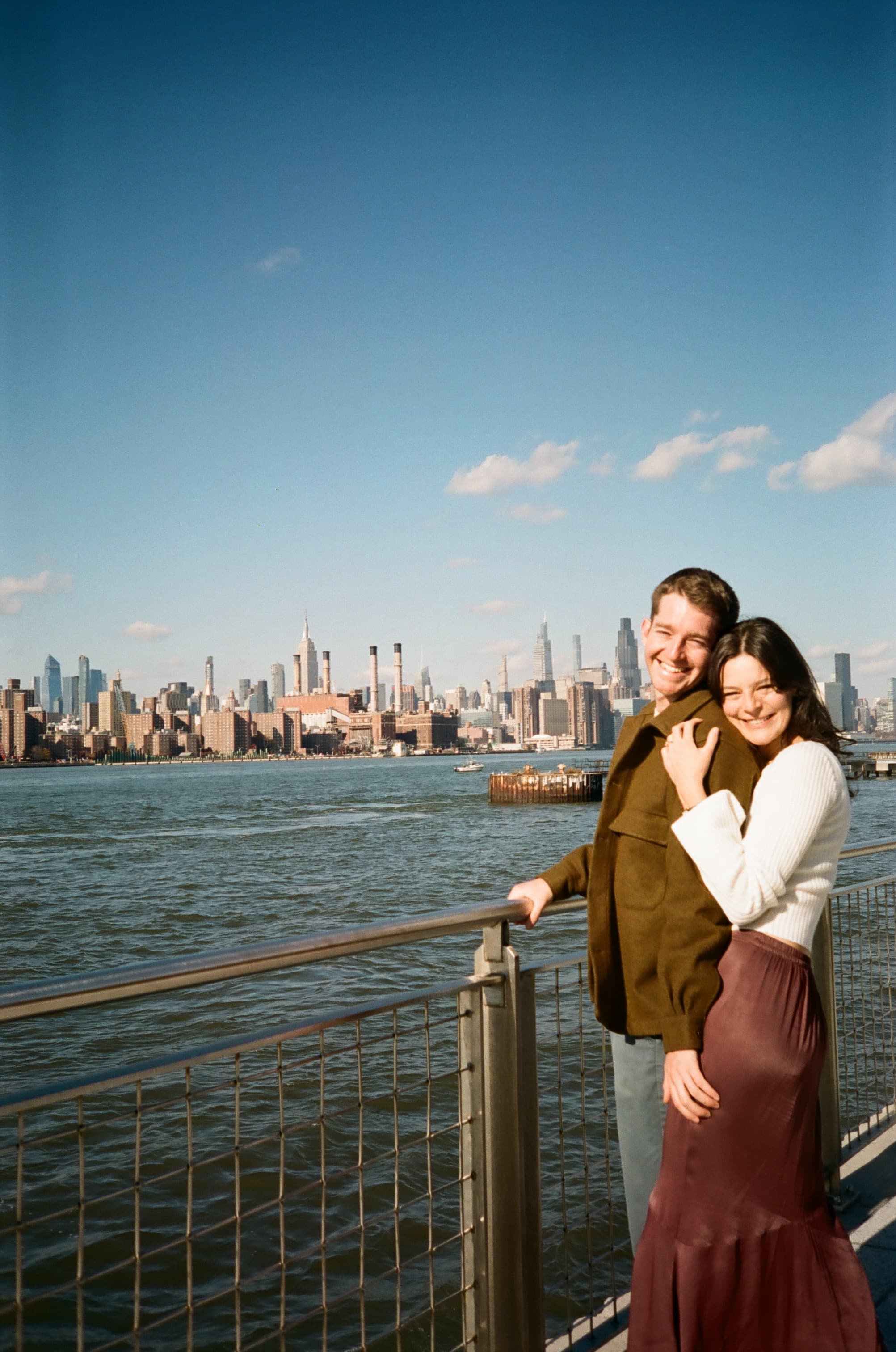 Emily and Will hugging with the city skyline